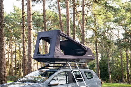 The TentBox GO with all windows open, against a forest backdrop