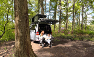 Dannii and daughter Ember sit in front of their VW campervan in the woods with a TentBox Classic 2.0 on top