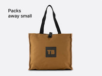 The TentBox Camping Chair Cushion packed away into a convenient, stylish mustard storage bag, with overlay text saying "Packs away small"