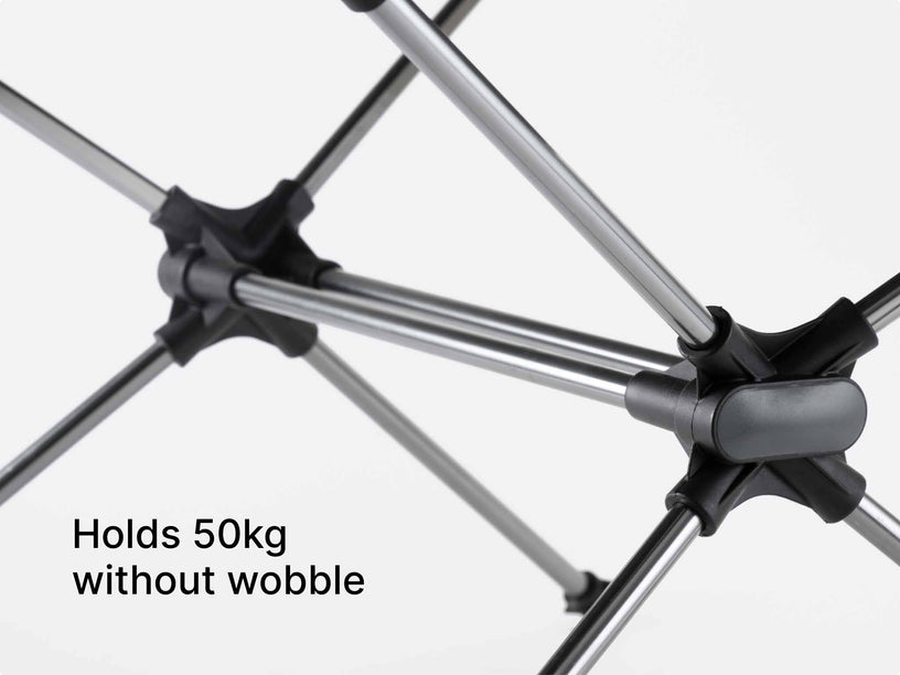 Close-up of a TentBox Camping Table with black and grey connector joints and silver poles, with text reading 'Holds 50kg without wobble' on a light grey background.
