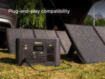 Portable TentBox power station with solar panels on grass, indicating plug-and-play compatibility.