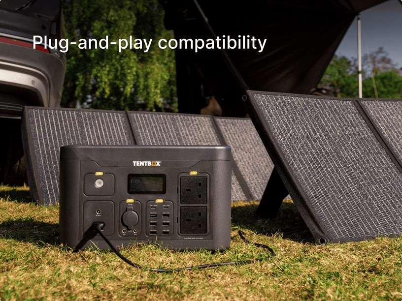 Portable TentBox power station with solar panels on grass, indicating plug-and-play compatibility.