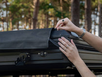 Close up shot of woman installing TentBox Cargo 1.0 Tunnel Awning