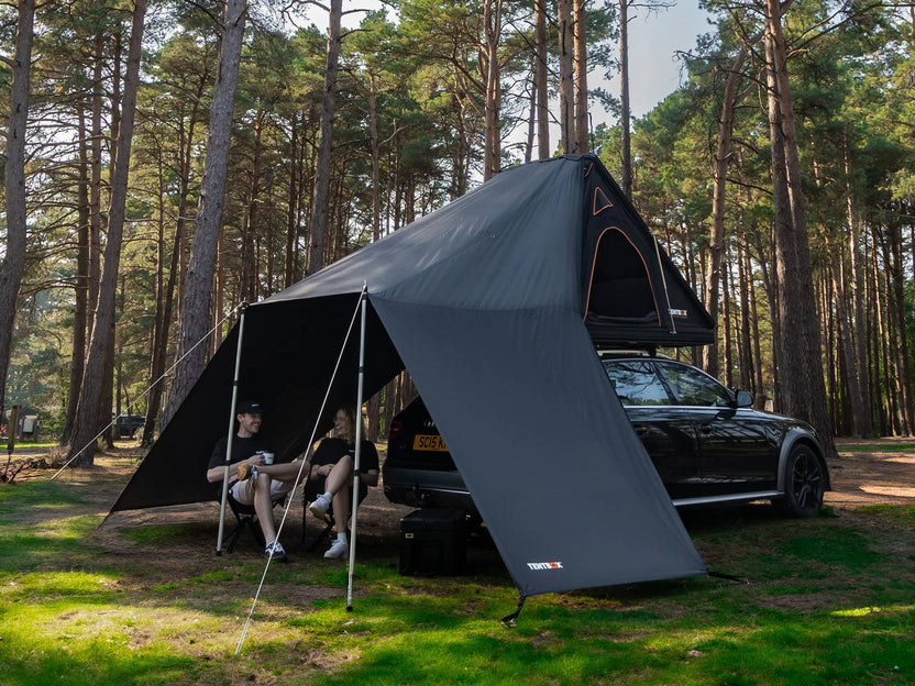 Two people enjoying themselves sat under the TentBox Cargo 1.0 Tunnel Awning