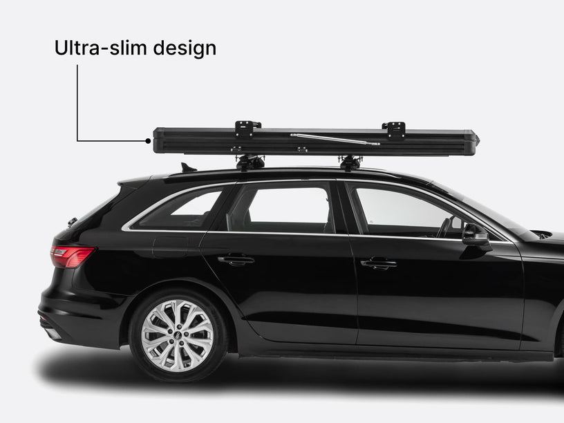 Image showing the ultra slim design of the TentBox Cargo 2.0 roof tent on top of a black car. 