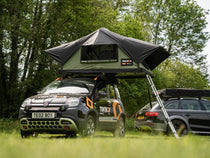 TentBox Lite 2.0 in the Forest Green colour, parked in a campsite field.