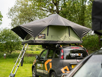 TentBox Lite 2.0 in the Forest Green colour, parked in a campsite field.