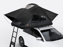 The new Flint coloured TentBox Lite roof tent open on the roof of a white car