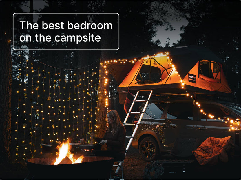 TentBox Lite 2.0 roof tent glowing with fairy lights at night, creating a cosy and inviting camping bedroom