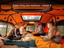 A family enjoying the TentBox Lite XL playing a card game showing that it can sleep 4 people as the largest roof tent from TentBox