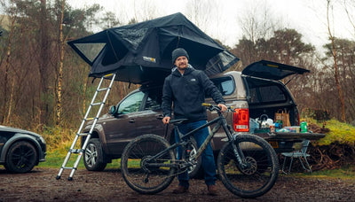 Man standing with his mountainbike in front of a TentBox Lite