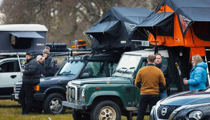 Members of the TentBox community having a conversation in front of their roof tents