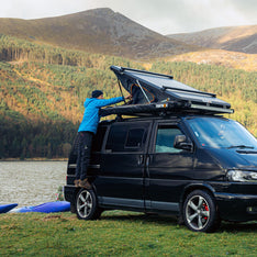 A camper in the Lake District opening his TentBox Cargo 1.0 roof tent that is installed on a Volkswagen Transporter