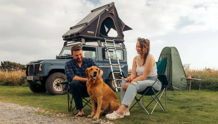A couple and their dog camping with their TentBox Cargo 1.0 roof tent