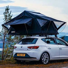 A TentBox Lite roof tent on a Seat Leon car, parked at a camping spot in the mountains