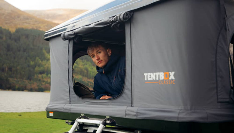Man sitting in TentBox Classic, enjoying a view over a lake